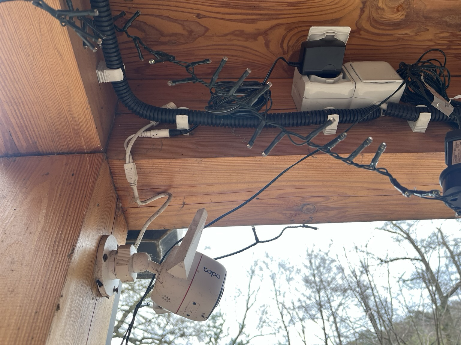 Outdoor surveillance camera at easy to reach height with its power supply plugged into mains right next to it.