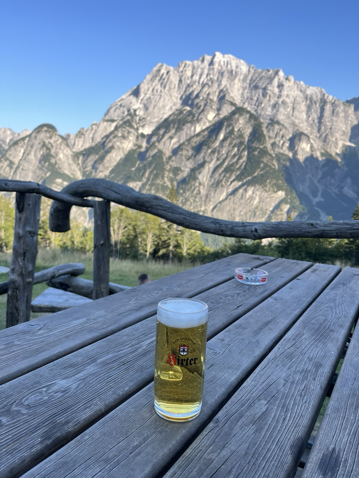 View with beer in the foreground and high rocky mountains in the background